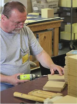 A worker uses a drill during the manufacture of an Imagine Design product. The company uses it's Minnesota-based manufacturing operation to provide jobs and teach job skills for people with barriers to employment.
